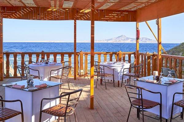 Terrasse des Parrotel Beach Resorts mit Blick auf das Meer und Berge