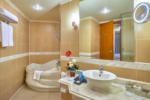 Badezimmer im Parrotel Beach Resort mit Badewanne, Spiegel und Handtüchern