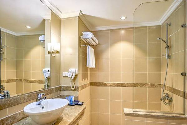Badezimmer im Parrotel Beach Resort mit Badewanne, Dusche, Waschbecken und Spiegel