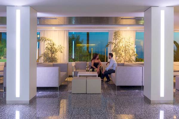Lobby-Lounge-Bereich des HSM Golden Playa Hotels mit Paar auf Sofas.