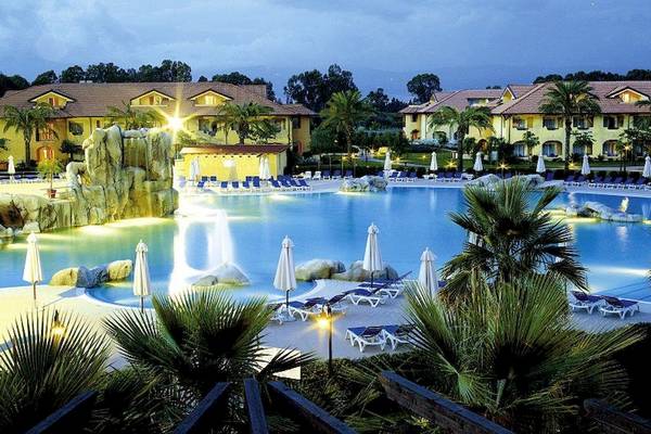 Außenpool des Falkensteiner Club Funimation Garden Calabria bei Nacht mit Wasserfall und Liegestühlen
