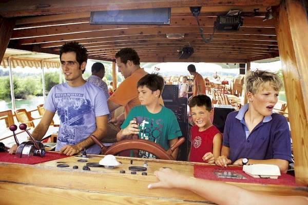 Kinder und Erwachsene steuern ein Boot im Falkensteiner Club Funimation Garden Calabria.