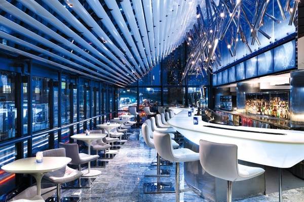 Innenansicht der Bar im Hyatt Grand Central New York mit blauer Beleuchtung und modernen Möbeln.