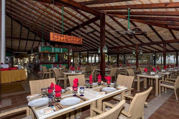 Innenbereich des Restaurants im Playabachata Spa Resort mit gedeckten Tischen und einer Bar.