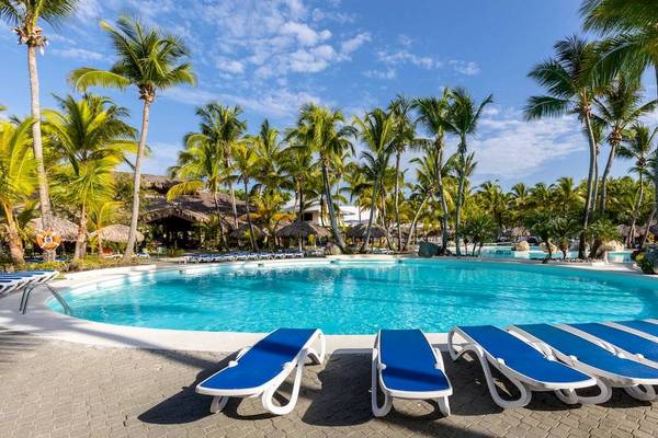 Pool des Playabachata Spa Resorts mit blauen Liegen unter Palmen