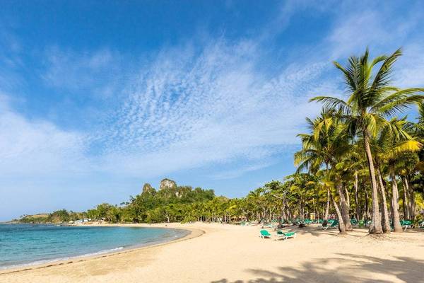 Strand des Playabachata Spa Resorts mit blauem Himmel und grünen Palmen