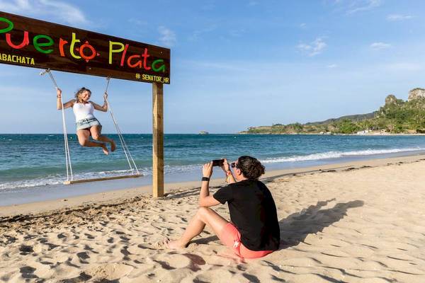 Junge Frau auf einer Schaukel am Strand von Playa Bachata, Fotograf in der Nähe