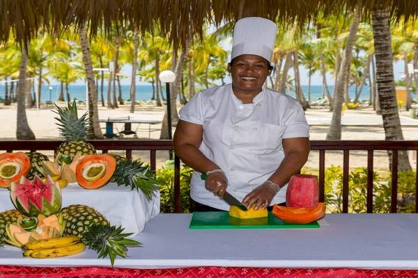 Eine Köchin des Playabachata Spa Resorts schneidet Obst auf einer Terrasse.