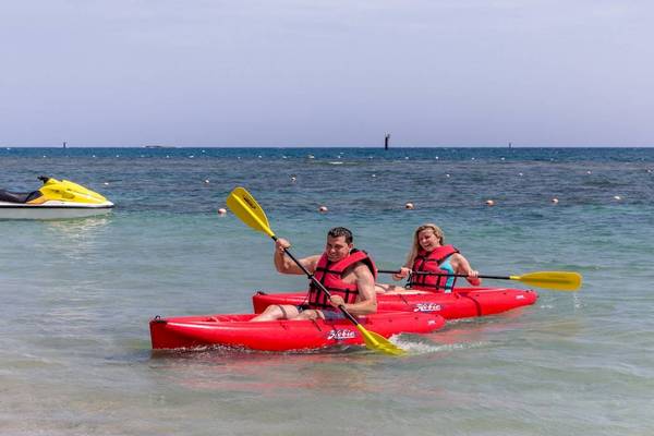 Zwei Leute im Kajak mit Jetski im Hintergrund am Playabachata Spa Resort.