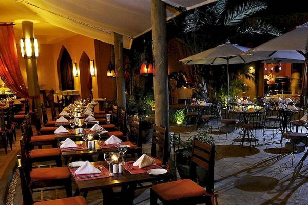 Außenbereich des SALT of Palmar Restaurants mit gedeckten Tischen und abendlicher Beleuchtung.