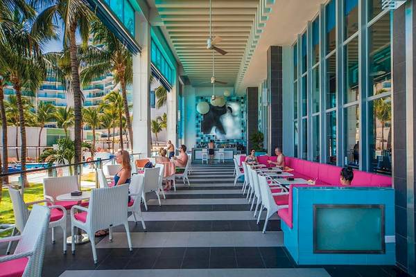 Loungebereich des Riu Cancun Hotels mit bunten Sitzgelegenheiten und Palmen.