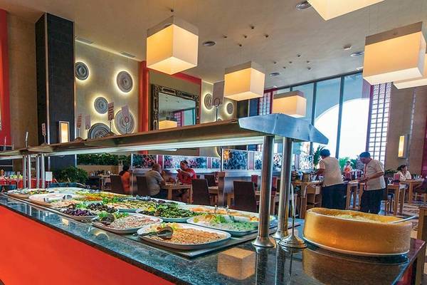 Buffetbereich im Riu Cancun Hotel mit verschiedenen Gerichten und Gästen.