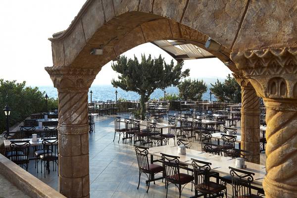 Terrasse im Club Resort Atlantis mit Blick auf das Meer und viele Tische und Stühle.