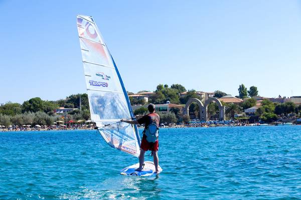 Ein Mann windsurft in der Nähe des Club Resort Atlantis am Strand.
