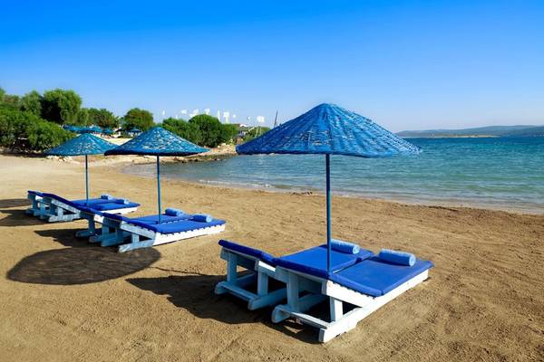 Strand mit Liegen und blauen Sonnenschirmen im Club Resort Atlantis
