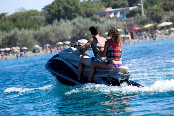 Zwei Leute auf Jetski im Meer vor Strand