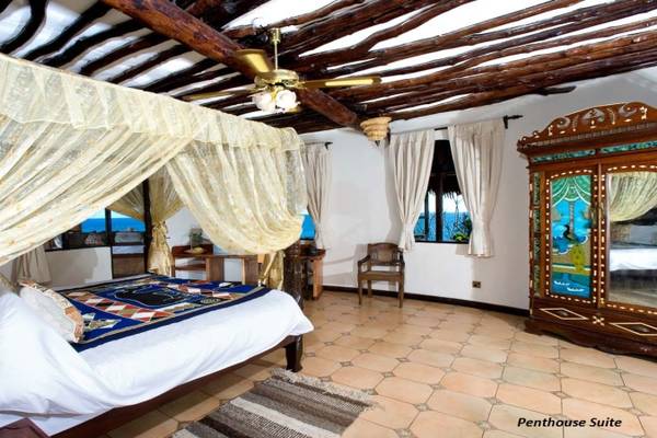 Schlafzimmer im Sands at Chale Island Resort mit Himmelbett, Holzdecke und Meerblick.