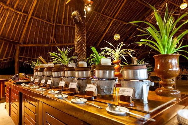 Speisebereich im Sands at Chale Island Resort mit Pflanzen und Töpfen.