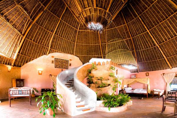Innenansicht des Sands at Chale Island Resorts mit geschwungener Treppe und Pflanzen.