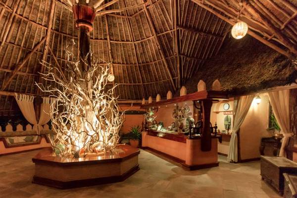Lobby des Sands at Chale Island Resort mit zentralem Lichtobjekt und Rezeptionstresen.