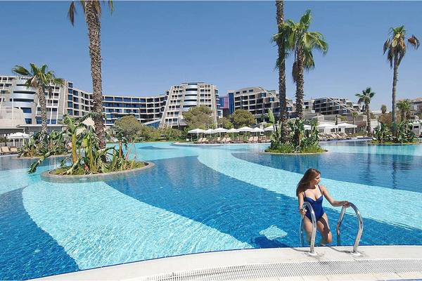 Ein Swimmingpool im Susesi Luxury Resort mit einer Frau, die gerade einsteigt.
