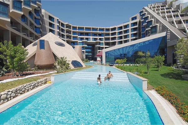 Zwei Personen genießen das Schwimmen im Außenpool des Susesi Luxury Resorts.