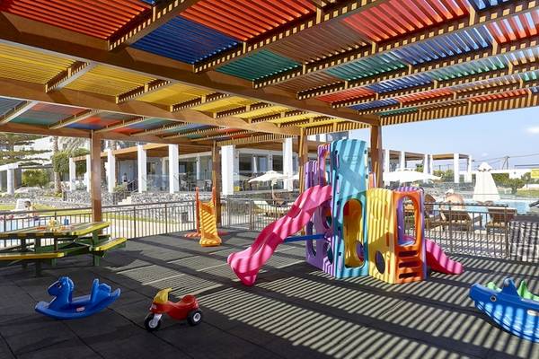 Kinderspielplatz im Astir Beach Hotel in Kreta, geschützt unter einer bunten Pergola.