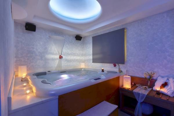 Jacuzzi-Raum im Astir Beach Hotel auf Kreta mit beleuchteten Kerzen und Wasser.