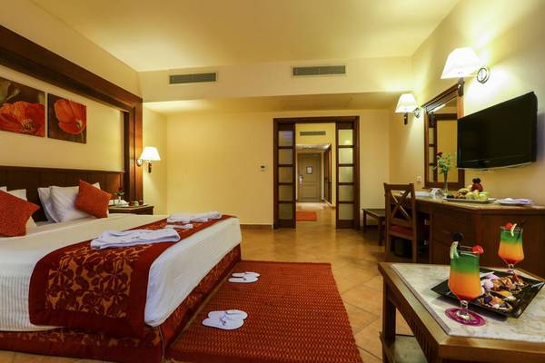 Hotelzimmer im Charmillion Club Aqua Park mit Bett, Tisch, Fernseher und Dekor.