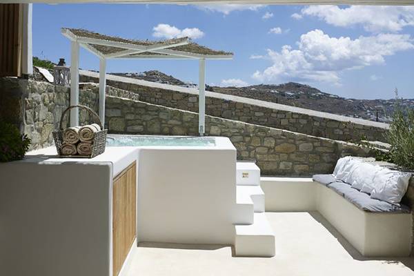 Außenbereich des Rocabella Mykonos Art Hotel & Spa mit Whirlpool unter einem Pavillon.