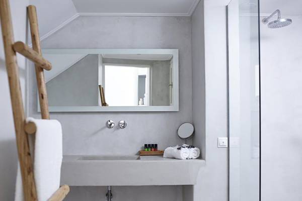 Badezimmer im Rocabella Mykonos Art Hotel & Spa mit Dusche, Waschbecken und Spiegel.