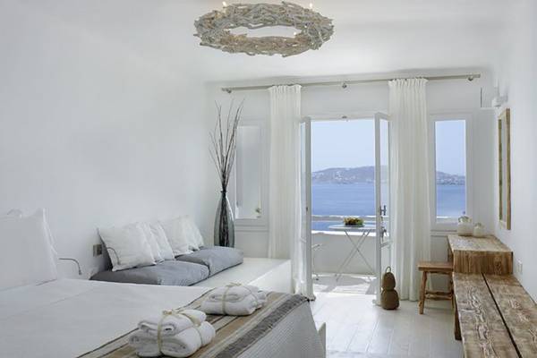 Schlafzimmer im Rocabella Mykonos Art Hotel mit Blick auf das Meer.