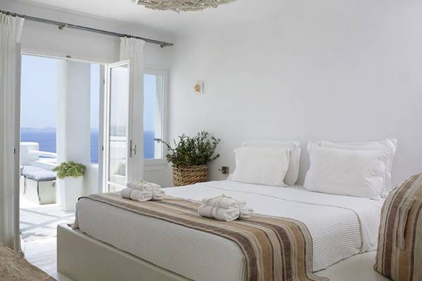 Schlafzimmer im Rocabella Mykonos Art Hotel mit Blick auf das Meer.