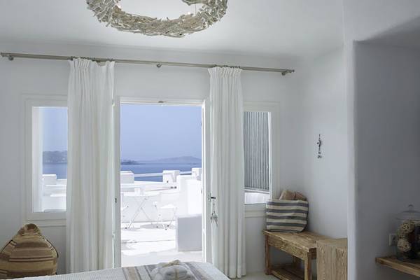 Innenansicht eines Zimmers im Rocabella Mykonos Art Hotel & Spa mit Blick auf das Meer.