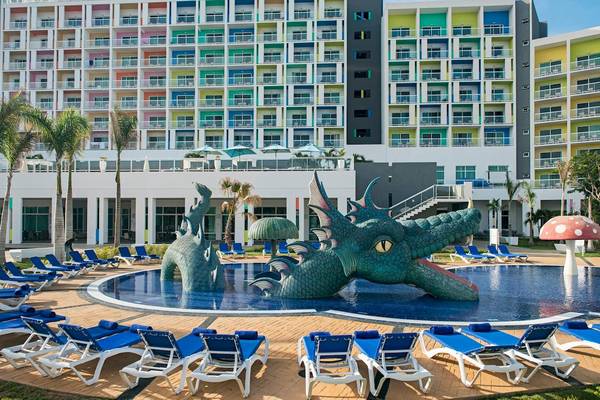 Farbiges Hotel Iberostar Origin Bella Vista Varadero mit Swimmingpool und Liegestühlen.