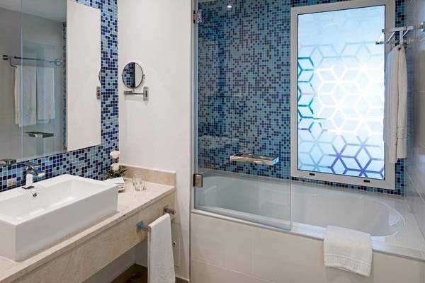 Badezimmer im Iberostar Origin Bella Vista Varadero Hotel mit blauen Fliesen und einer Badewanne.