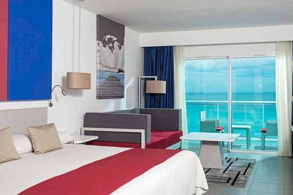 Hotelzimmer im Iberostar Origin Bella Vista Varadero mit Meerblick, inklusive Bett, Sofa, Tisch und Balkon.