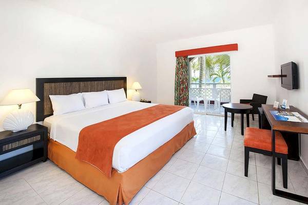 Zimmer im Casa Marina Beach Resort mit einem Bett, Schreibtisch und einem Balkon.