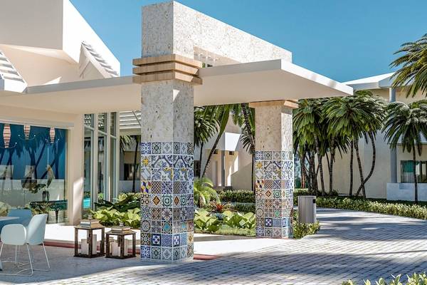 Außenbereich des Coral Level at Iberostar Selection Bávaro mit bunten Säulen und modernen Möbeln.