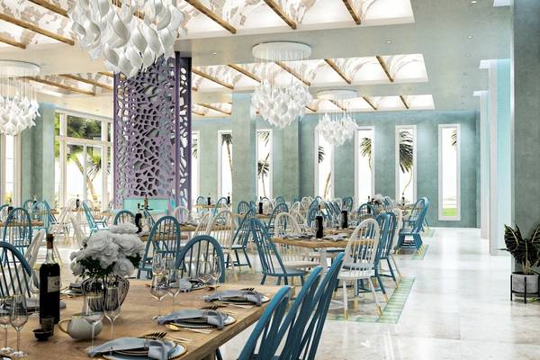 Restaurant im Coral Level at Iberostar Selection Bávaro mit blauen Stühlen und Tischen, Deckenlampen und einer großen Fensterfront.