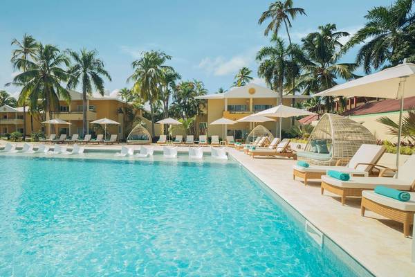 Außenpool des Coral Level at Iberostar Selection Bávaro mit Loungeliegen und Sonnenschirmen