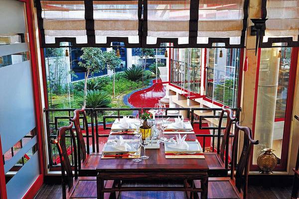 Innenansicht des Restaurants im Susesi Luxury Resort mit gedecktem Tisch und Blick auf den Garten.