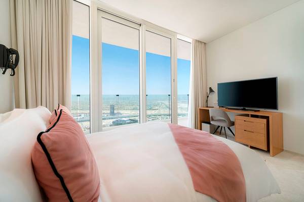 Ein modernes Zimmer im FIVE Jumeirah Village Hotel mit großem Bett und Ausblick auf die Stadt.