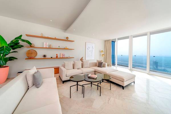 Wohnzimmer im FIVE Jumeirah Village Hotel mit modernem Design, großen Fenstern und Meerblick.