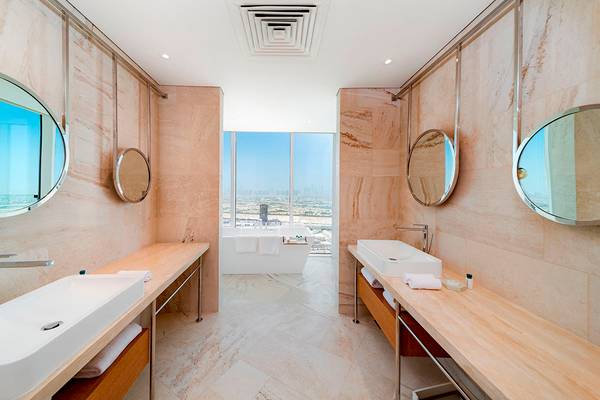 FIVE Jumeirah Village Hotel Badezimmer mit zwei Waschbecken und Badewanne im Hintergrund.