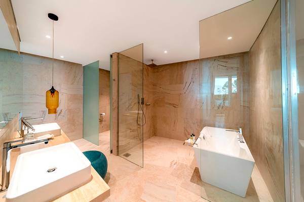 Badezimmer mit Doppelwaschbecken und Dusche im FIVE Jumeirah Village Hotel.
