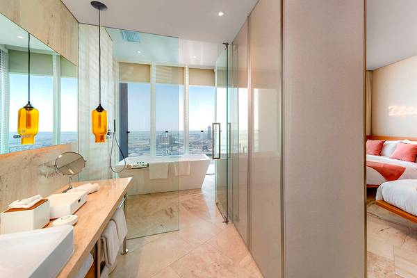 Badezimmer des FIVE Jumeirah Village Hotels mit Blick auf die Stadt und einem Bett