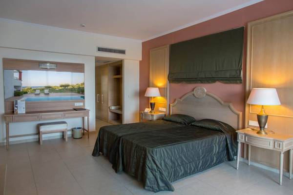 Schlafzimmer im Kresten Royal Euphoria Resort mit zwei Betten, Nachttischen und Lampen.