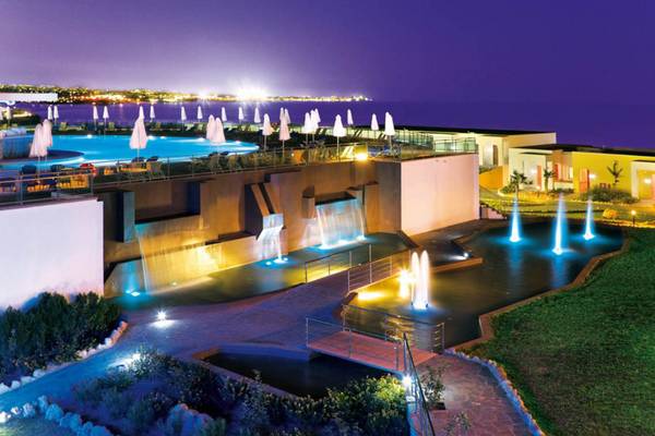 Außenbereich des Kresten Royal Euphoria Resorts bei Nacht mit beleuchtetem Pool und Wasserfällen.