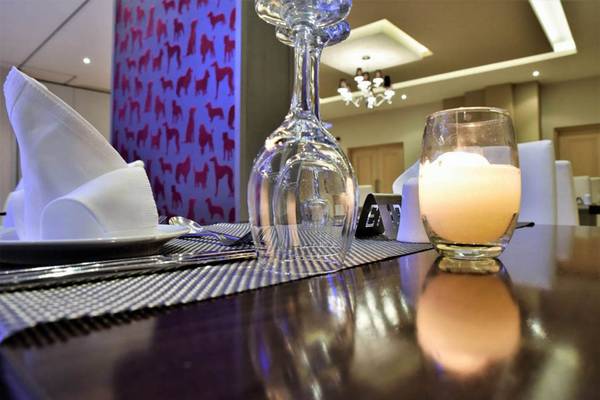 Ein Tisch im Kresten Royal Euphoria Resort mit einem leeren Glas, einem brennenden Kerze und ein gedeckter Platz